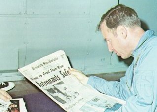 A photo of astronaut,Lovell reading the newspaper