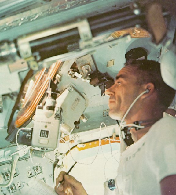 A photo of astronaut, Cunningham looking through a spacecraft window
