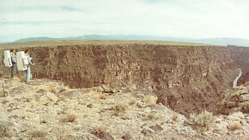 A photo of Apollo 15 astronauts,Irwin and Scott, standing at the rim of the Rio Grande gorge