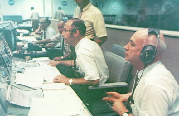 A photo of Low and Gilruth looking at the television monitor