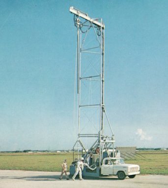 A photo of a pulley-mounted truck lifting an astronaut slightly off the ground