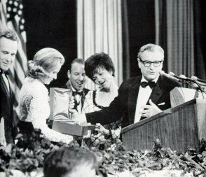 A photo of New York Governor Nelson Rockefeller presenting a commemorative plates to wives of astronauts