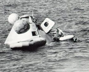 A photo of Apollo 7 astronaut climbing aboard a life raft